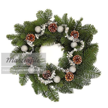 Christmas wreath of spruce pine fir, pine cones with sparkling silver bauble decorations and isolated over white background.