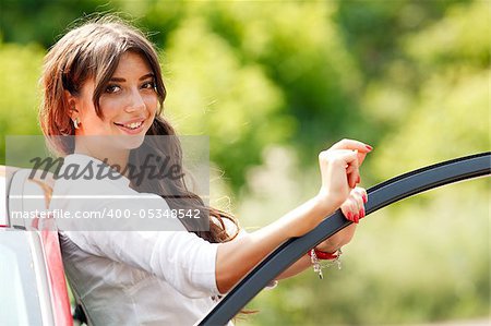 Young pretty woman in the red car