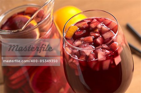 Refreshing red wine punch called sangria mixed with orange, apple, mango pieces served in wine glass (Selective Focus, Focus on the fruit pieces in the middle of the glass)