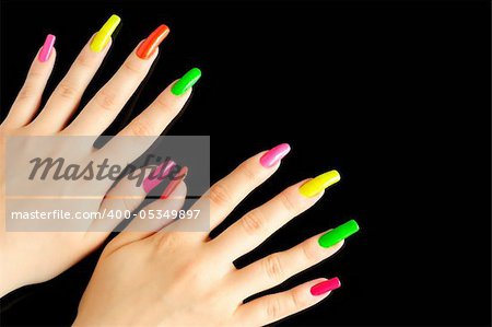 Colorful manicure on real nails over black background