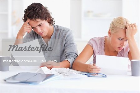 Stressed Couple with Paperwork in their living room