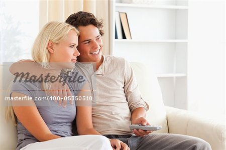 Cute couple watching TV in their living room