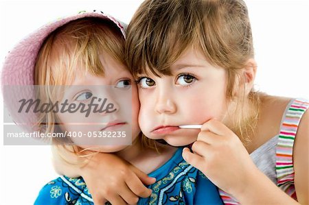Close-up of two sweet little girls, one with lollipop in mouth hugging