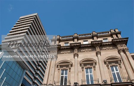 A Skyscraper and a vintage stone building in an english city