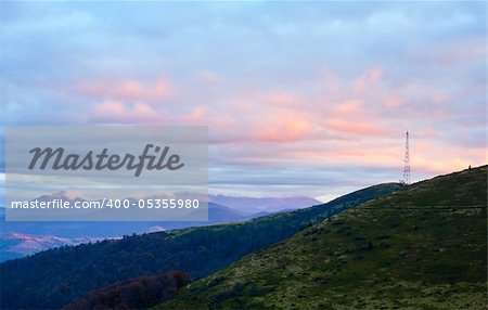 Autumn evening plateau landscape with lust golden-pink sunlight on mountains and evening glow in sky