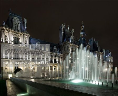 The lit fountains in front of the Hotel de Ville in Paris at night, nicely illuminated to show the "grandeur" of the city