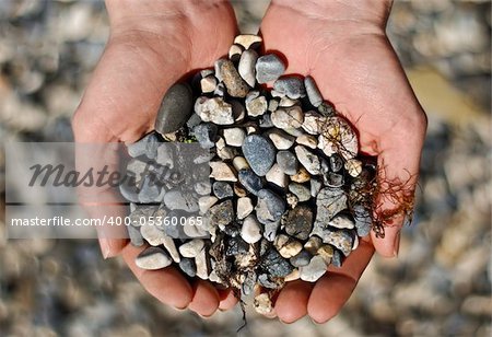 Abstract and Objects. Many small stones in hands