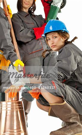 female construction worker holding hammer and crouching next to bucket