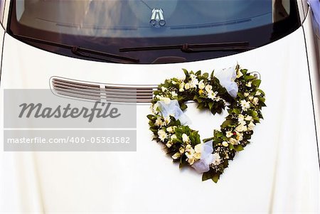 wedding wreath decoration in heart shape on white car