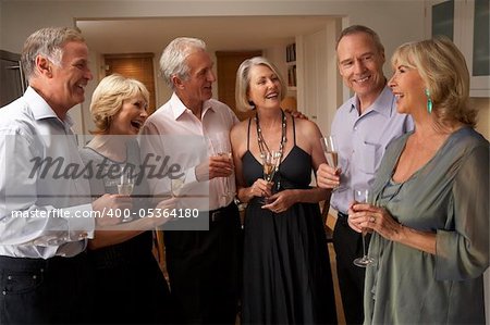 Friends Enjoying A Glass Of Champagne At A Dinner Party