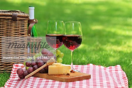 Various sorts of cheese, grapes and two glasses of the red wine