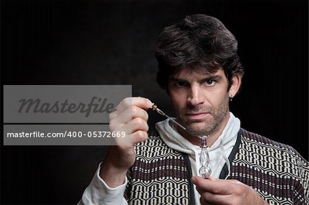 Caucasian wizard holds dropper and potion bottle