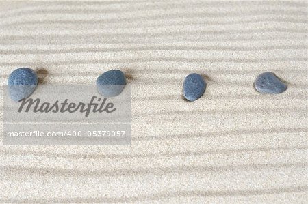 four stones on background of sand