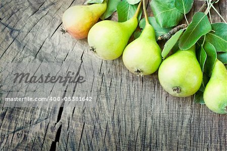 Freshly harvested pears on old wooden background