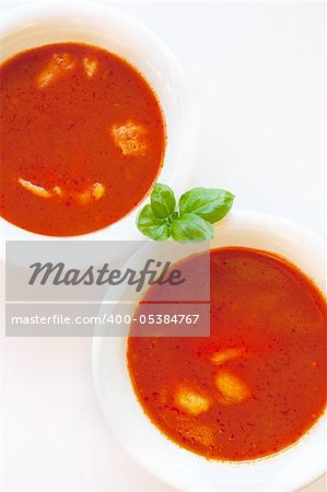 Delicious tomato soup with basil leaves and home made egg noodles. Shallow depth of field.