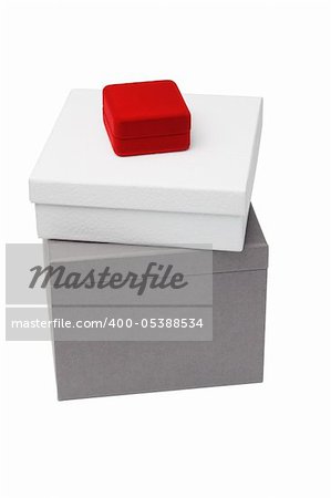 Small red jewelry box sitting on giftboxes on white background