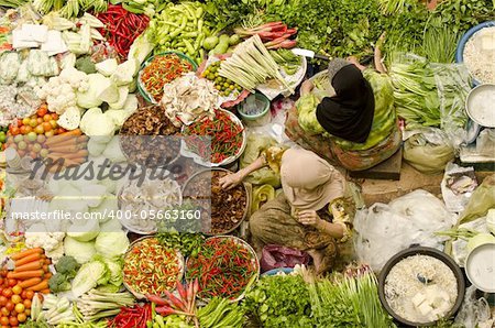 Vegetable market. Muslim woman selling fresh vegetables at Siti Khadijah Market market in Kota Bharu Malaysia.