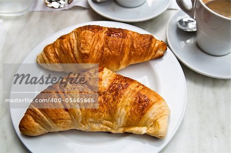 Breakfast with coffee and croissants on table