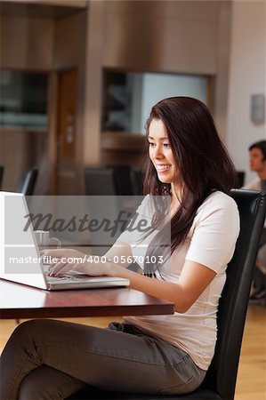 Portrait of a cute woman using a notebook in a cafe