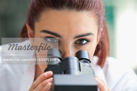 Close up of a scientist posing with a microscope in a laboratory