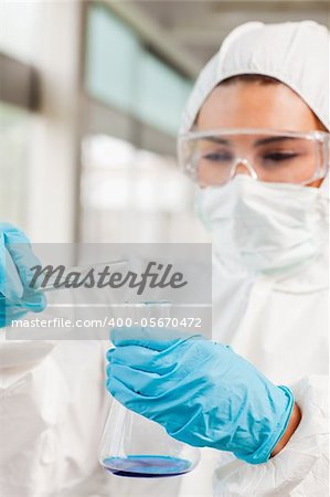 Portrait of a protected scientist pouring liquid in a laboratory