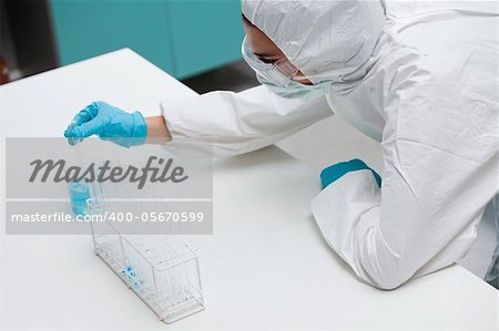 Protected science student pumping liquid with a pipette in a laboratory