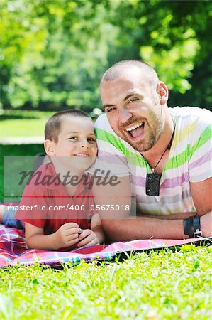 family father and son have fun at park on summer season and representing happiness concept