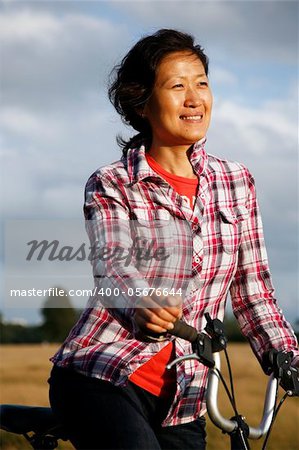 Woman in Richmond Park with bicycle at dusk