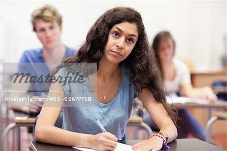 Focused student taking notes in a classroom