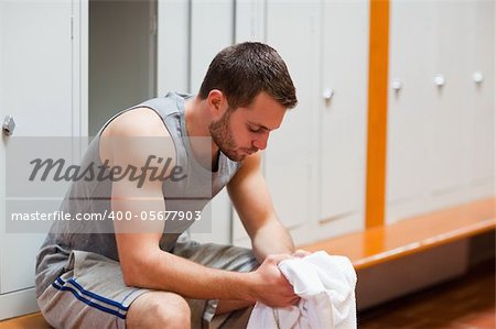 Sports student sitting on a bench with a towel