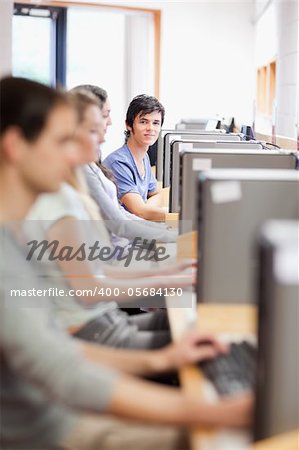Portrait of young fellow students in an IT room with the camera focus on the background