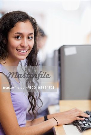 Portrait of a cute student with a computer in an IT room
