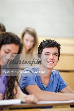 Student being distracted while his classmates are listening in an amphitheater