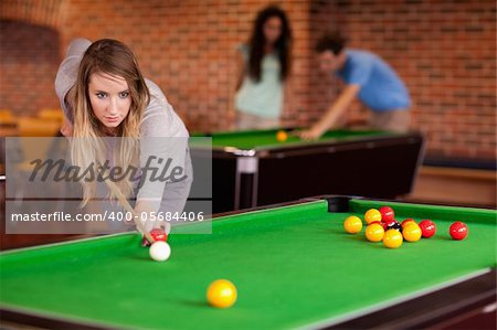 Student woman playing snooker in a student home