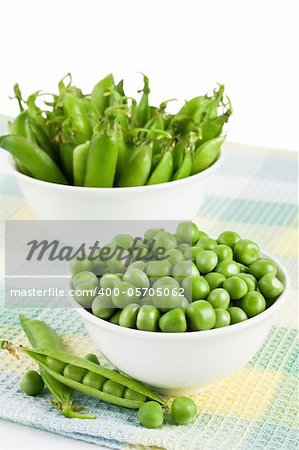 Pods green sweet organic peas in two bowl