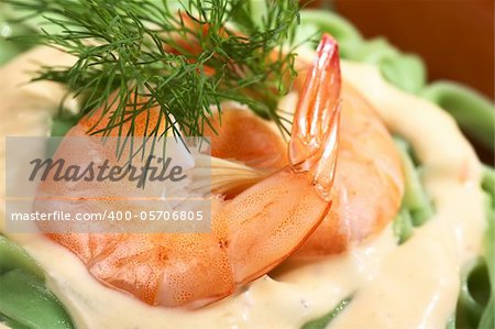 Green tagliatelle (ribbon noodle) with a cream sauce, shrimp and fresh dill (Selective Focus, Focus on the front lower edge of the shrimp)