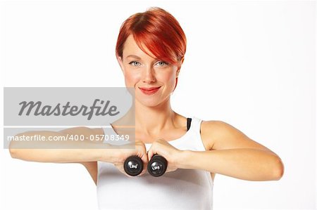 Beautiful caucasian woman curls dumbbells over white background