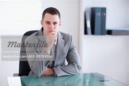 Thinking businessman sitting behind a table