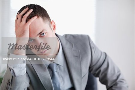 Close up of businessman who got bad news sitting behind a table