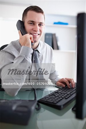 Smiling young businessman having a dialogue on the phone