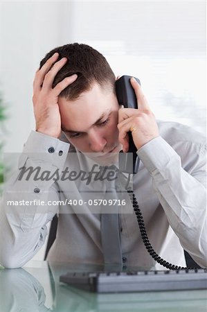 Depressed businessman getting disappointed on the phone