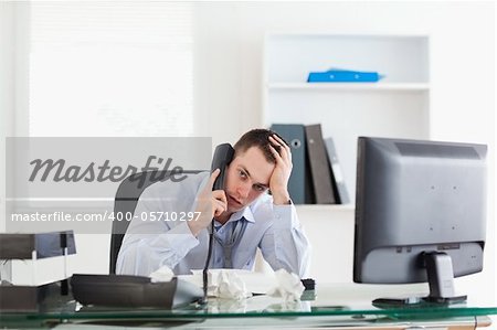 Depressed businessman trying to solve a problem on the phone