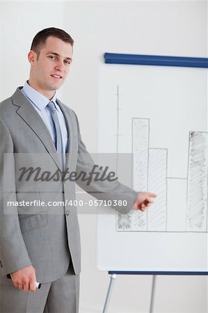 Young businessman pointing at chart