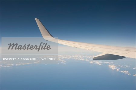 View from a large aircraft in flight with the wing against a blue sky background