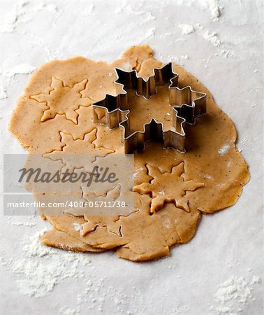 Making gingerbread cookies for Christmas. Gingerbread dough with star shapes and a cutter.