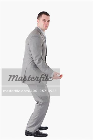 Portrait of a handsome young businessman carrying something against a white background