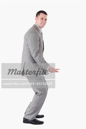 Portrait of a smiling businessman carrying something against a white background