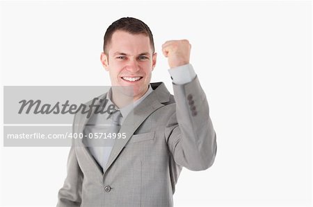 Young businessman with his fist up against a white background