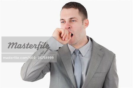 Tired businessman yawning against a white background