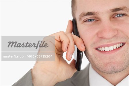 Close up of a happy businessman making a phone call against a white background